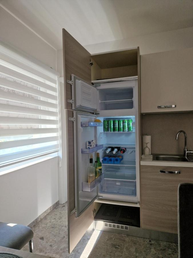 Odprt hladilnik z osnovnimi živili in pijačo, pripravljen za goste