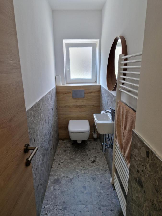 Minimalistično stranišče z lesenimi in kamnitimi detajli