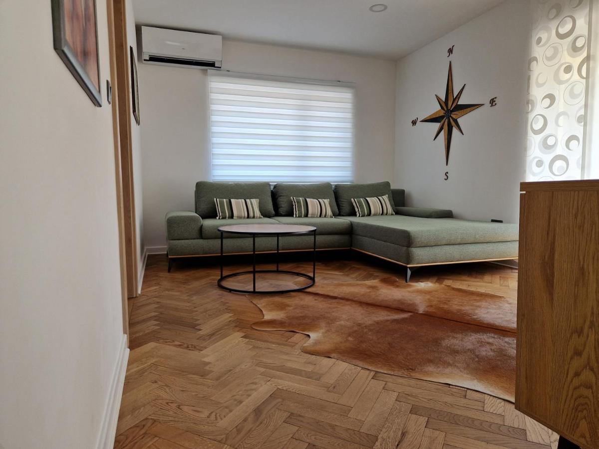 Svetla dnevna soba z moderno sedežno garnituro in naravnim parketom