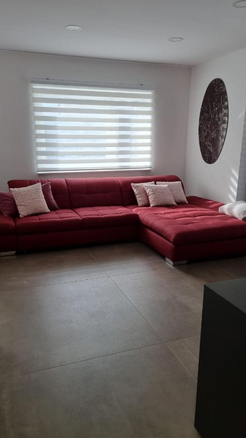Svetel dnevni prostor z moderno rdečo kotno sedežno garnituro